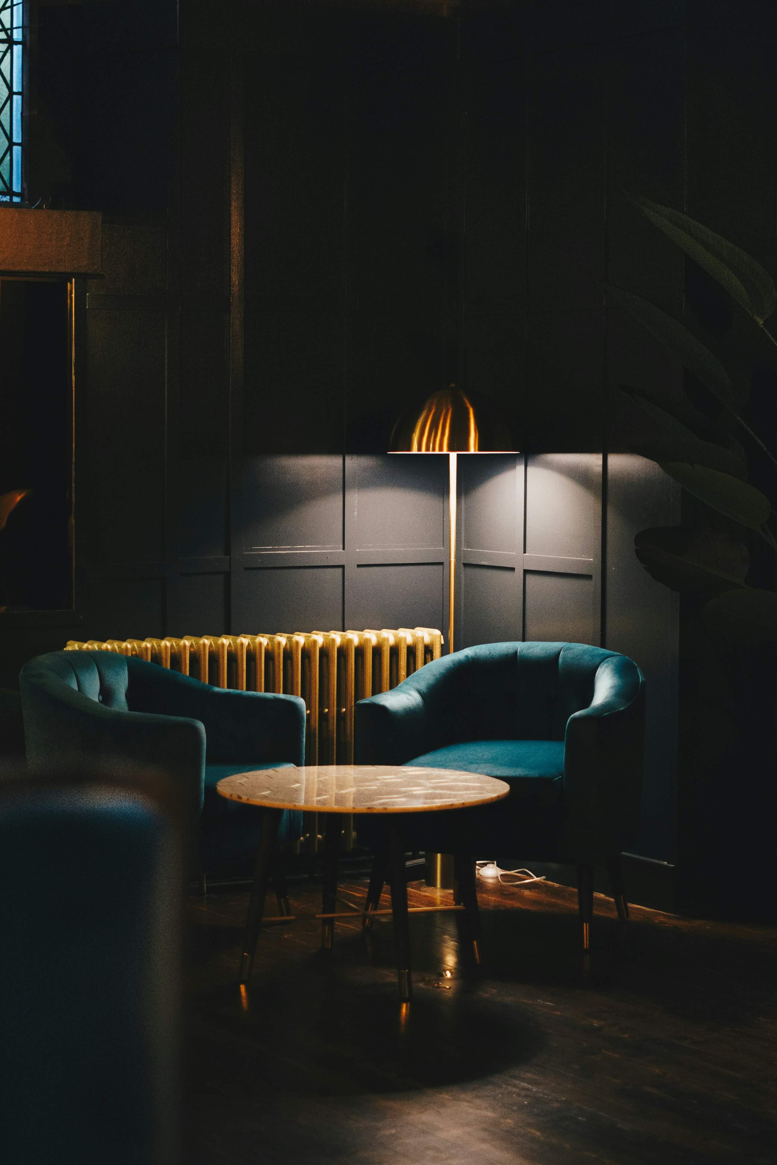 Dark lounge with armchairs and a small table.
