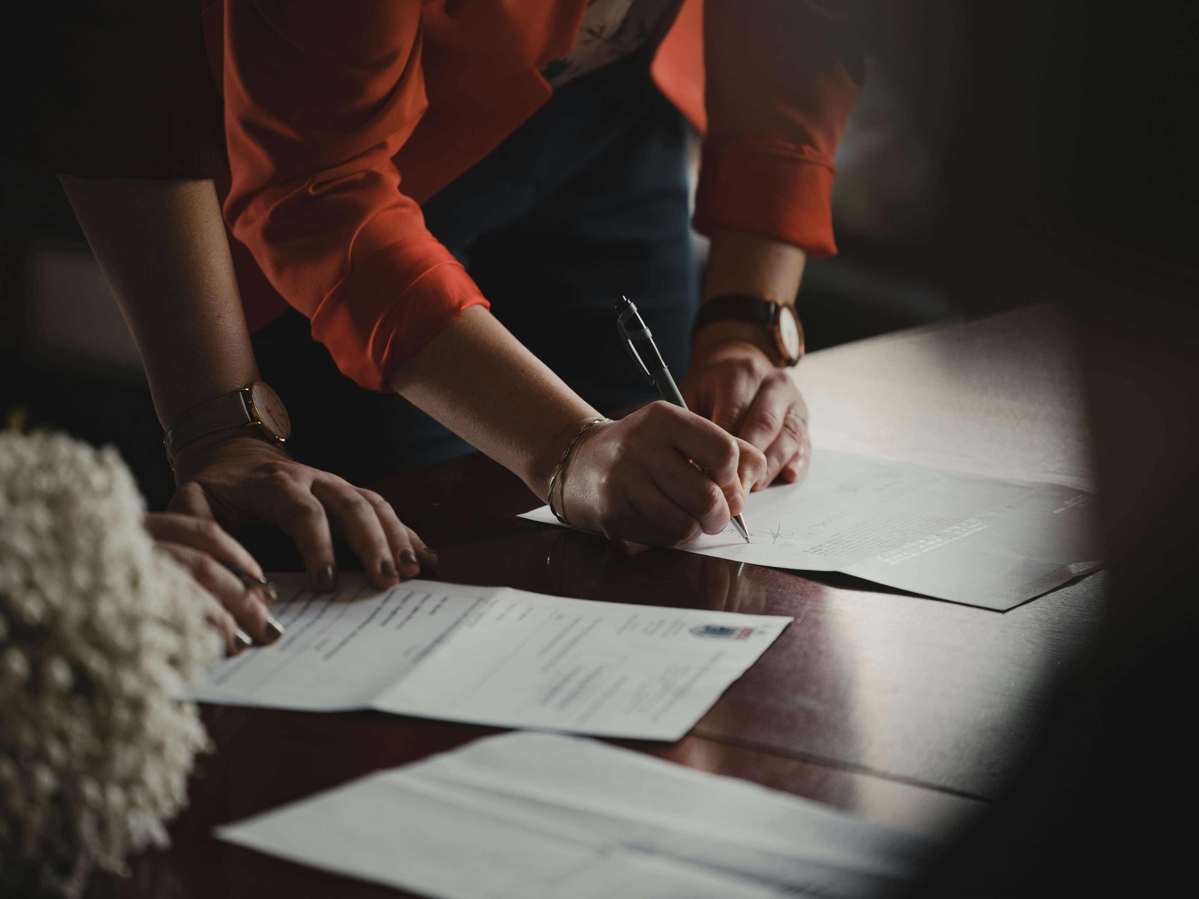 Person signing documents at a table